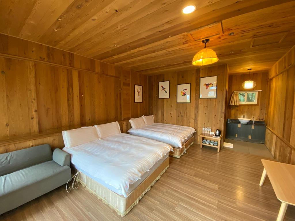a room with two beds and a couch in it at Spring Ground Resort in Ren&#39;ai