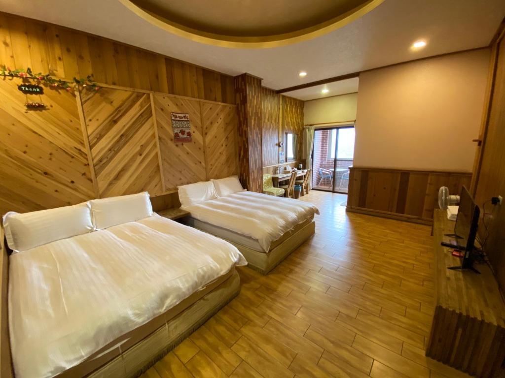 a hotel room with two beds and a table at Spring Ground Resort in Ren&#39;ai