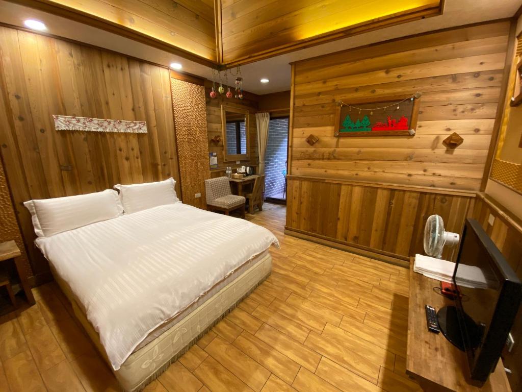 a bedroom with a bed in a room with wooden walls at Spring Ground Resort in Ren&#39;ai
