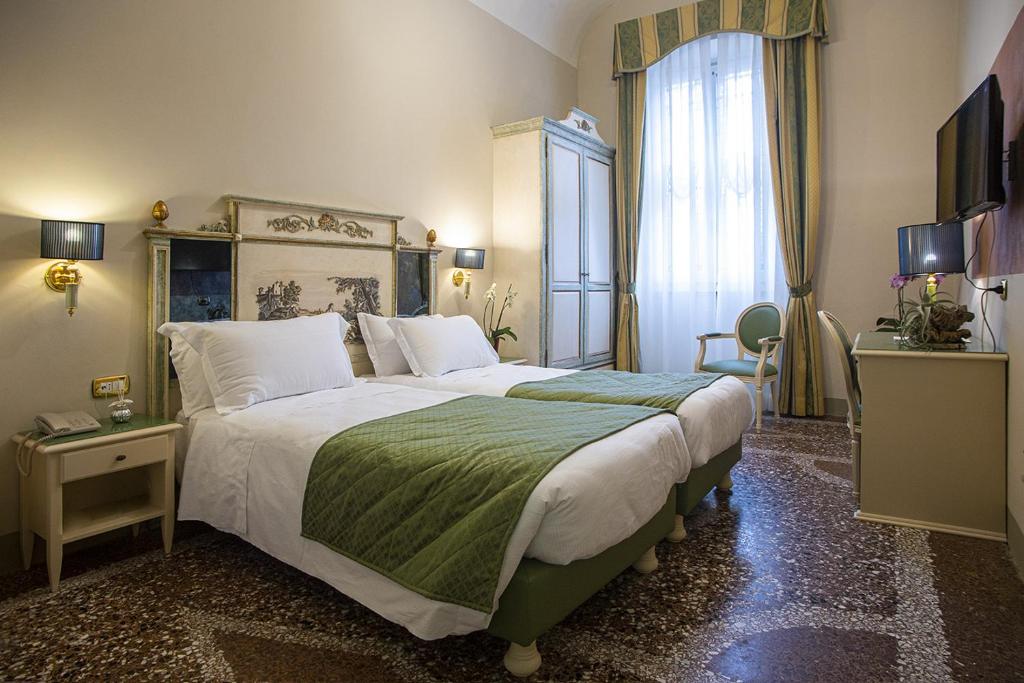 Postel nebo postele na pokoji v ubytování Hotel Donatello