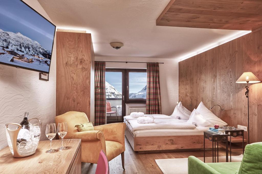a hotel room with a bed and a tv at Hotel Goldener Berg in Lech am Arlberg