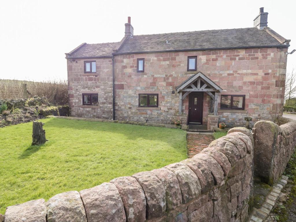 an old stone house with a large yard at The Farmhouse in Biddulph