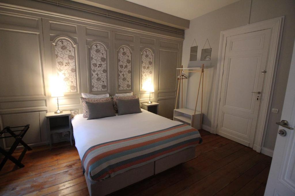 a bedroom with a large bed with two lamps at B&B L'Escapade Bordelaise in Bordeaux