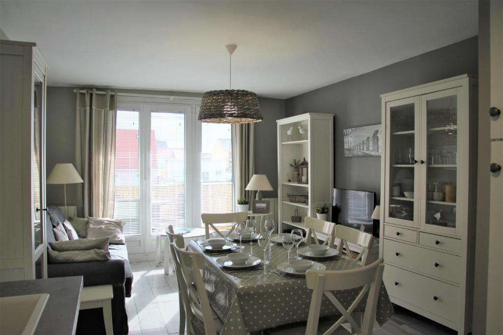 a living room with a dining room table with chairs at Plaisirs du bord de mer in Camiers
