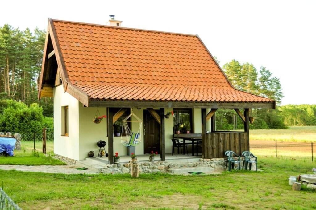 佩茨基的住宿－Leśny Zakątek Mazury，一座白色的小房子,拥有橙色的屋顶