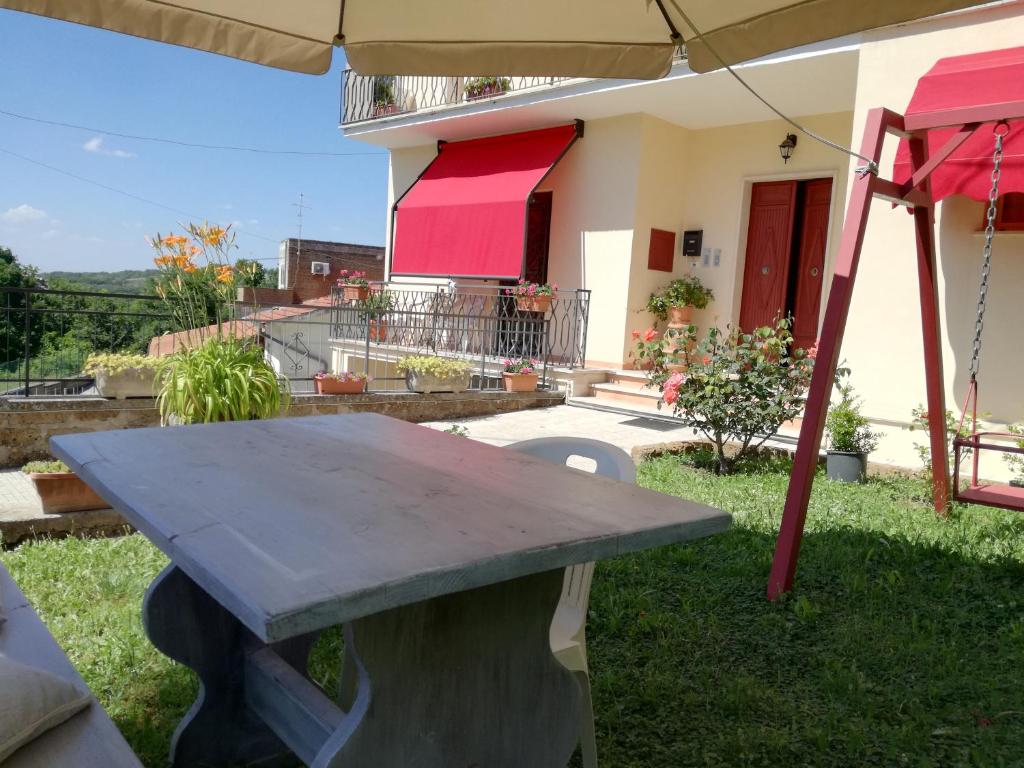 uma mesa de piquenique em frente a uma casa com um guarda-chuva em La Ripa Bed and Breakfast em Blera