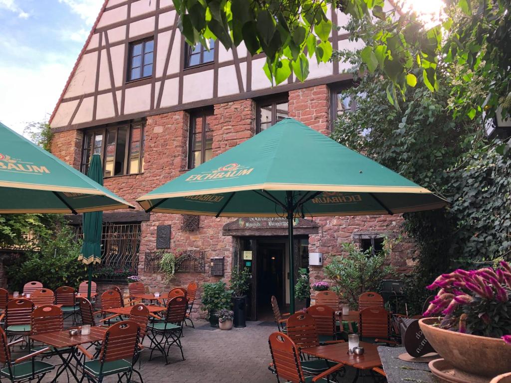 a patio with tables and umbrellas in front of a building at Hotel Weingärtner in Mannheim