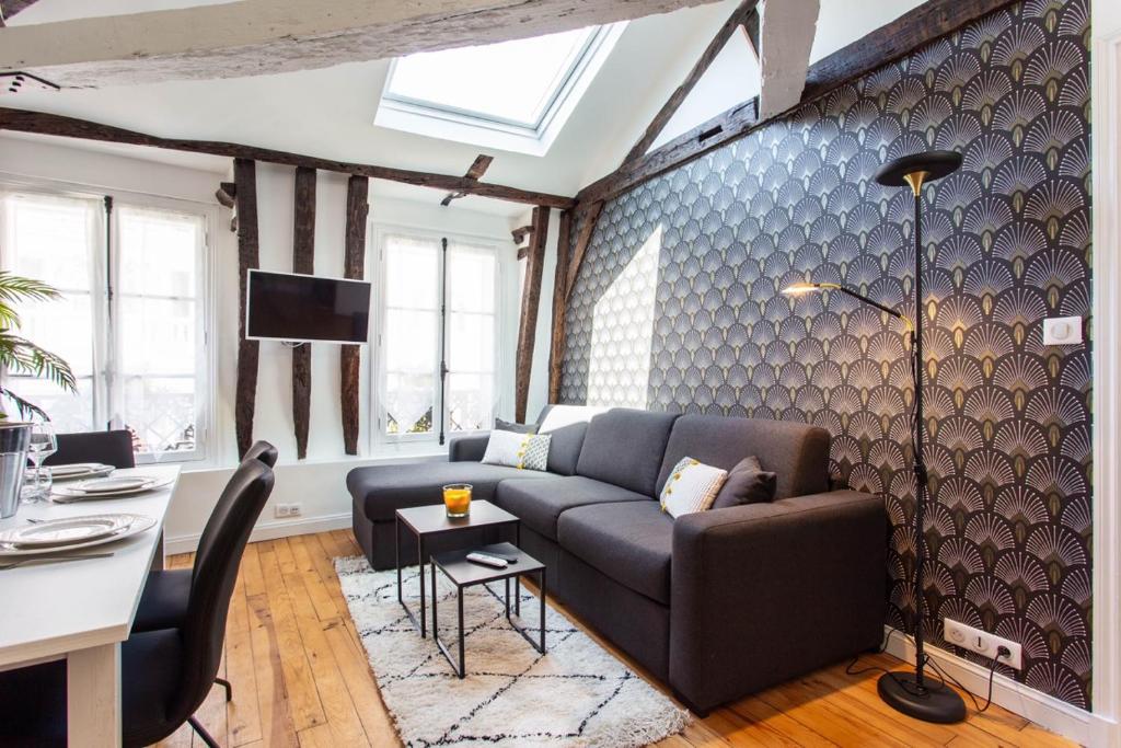 uma sala de estar com um sofá e uma mesa em CMG Rex - Bonne Nouvelle IV em Paris