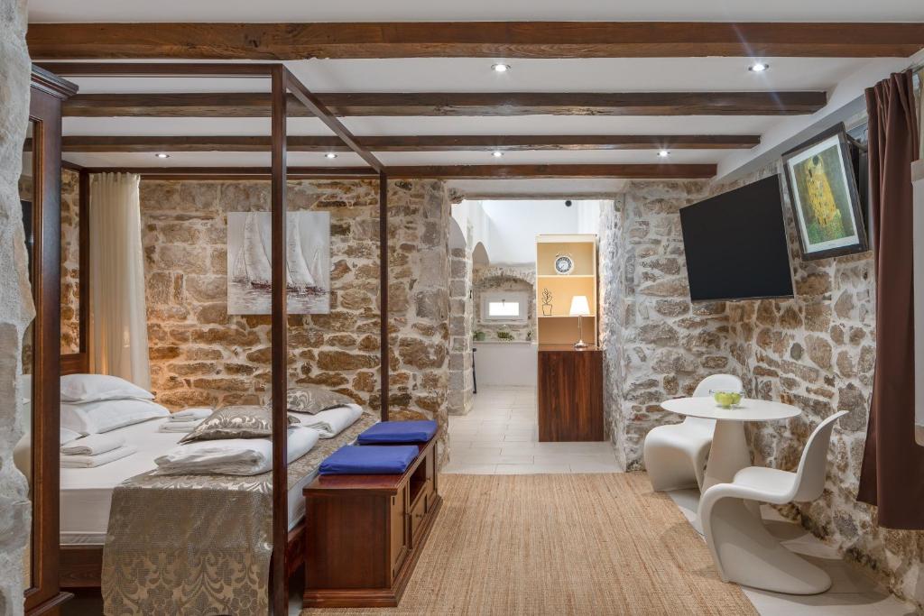 Habitación con cama, mesa y TV. en Awesome Stone House, en Split