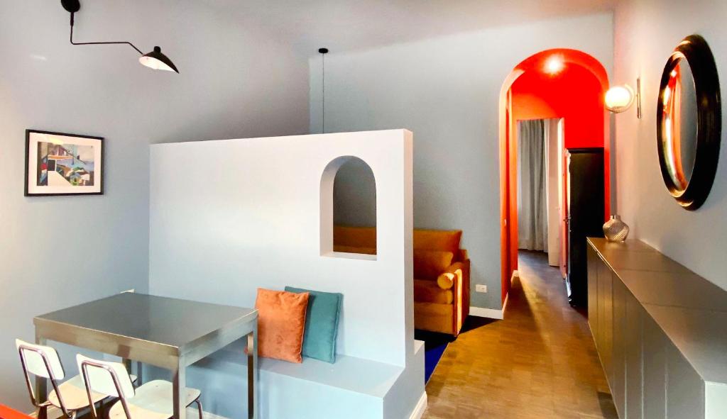 ミラノにあるCeruleo apartmentのテーブルと赤い鏡のあるダイニングルーム