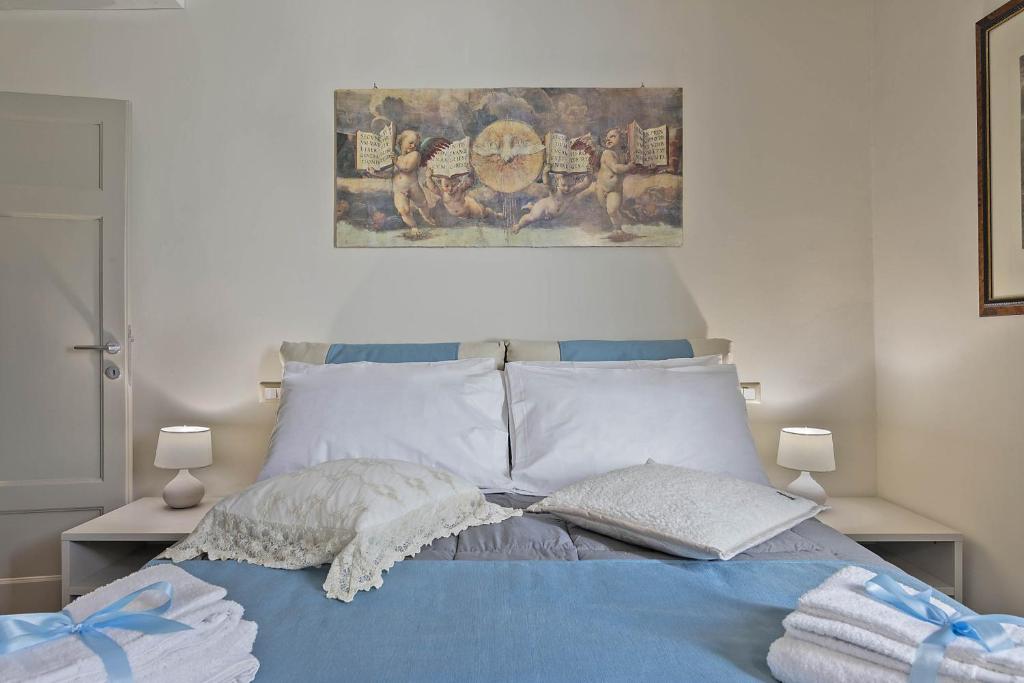 a bedroom with a blue bed with a painting on the wall at Villa Bonelli in Siena