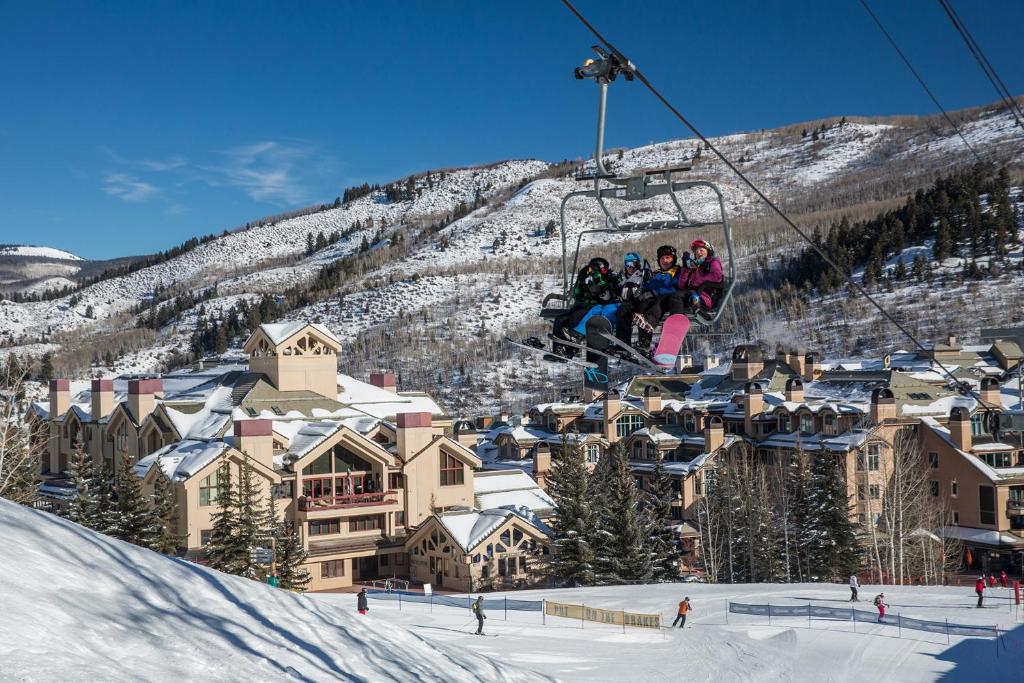 a group of people riding a ski lift in the snow at Strawberry Park True Ski In Ski Out by Vail Realty in Beaver Creek
