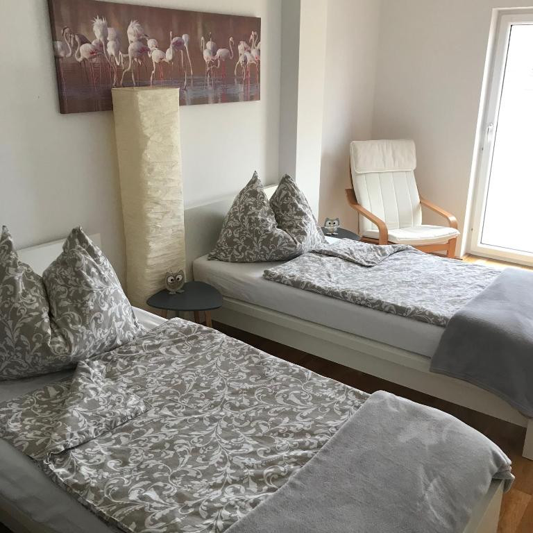 1 Schlafzimmer mit 2 Betten, einem Stuhl und einem Fenster in der Unterkunft LG Lovely Apartment in Stockerau