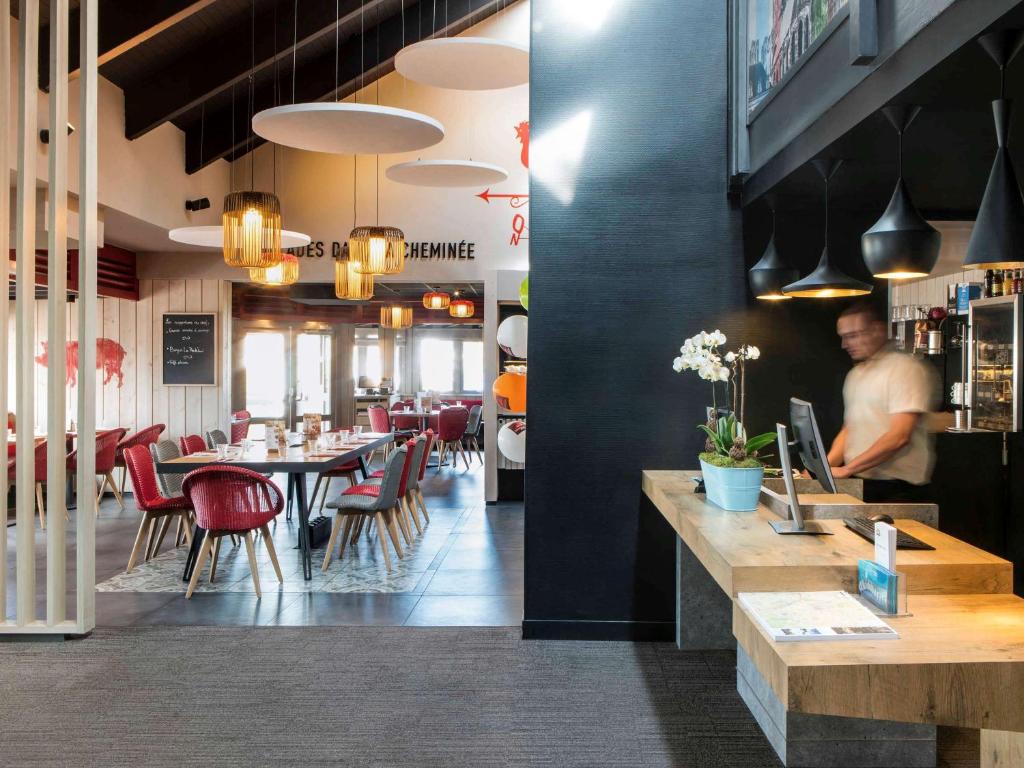 a man standing at a counter in a restaurant at ibis Reims Tinqueux in Reims