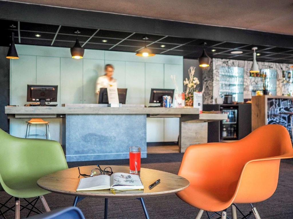 un restaurante con mesa y sillas con una persona de fondo en ibis Orange Centre, en Orange