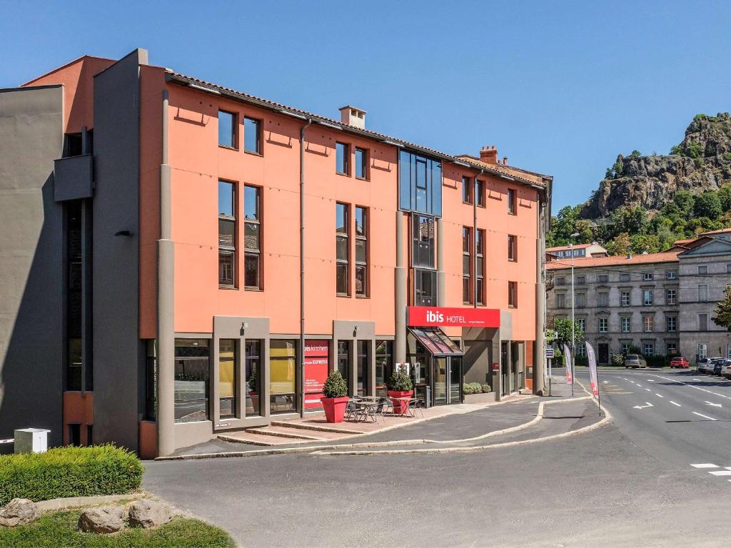 un bâtiment situé sur le côté d'une rue dans l'établissement ibis Le Puy-en-Velay Centre, au Puy-en-Velay