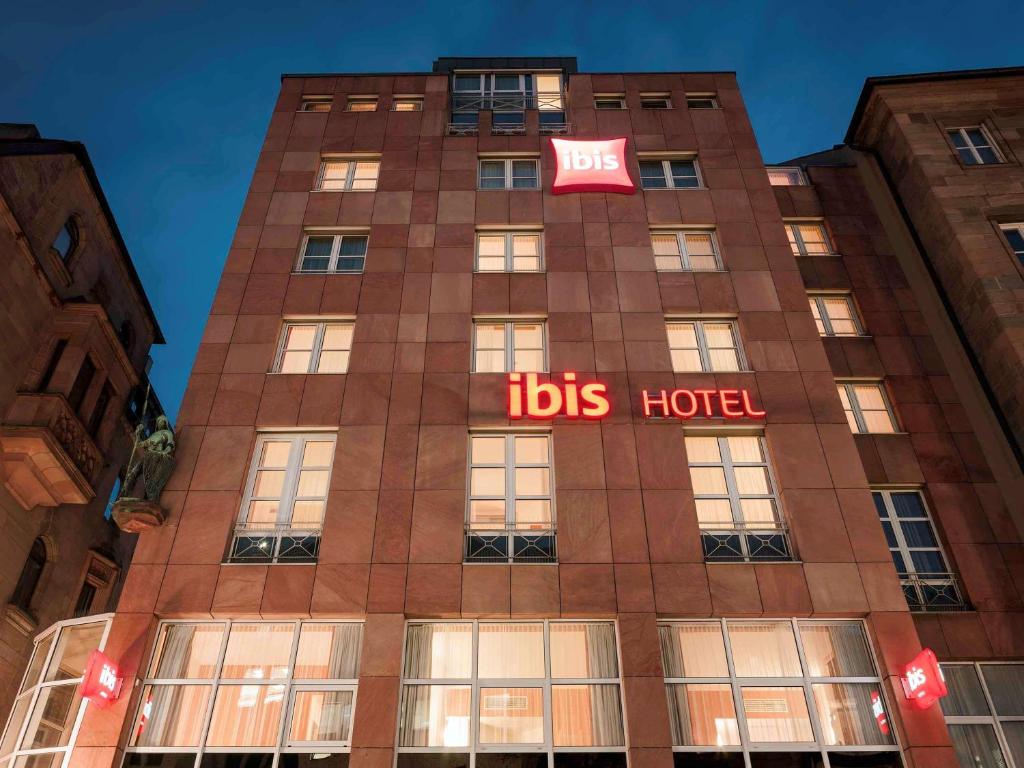 un edificio alto con un cartel de hotel de autobús. en ibis Hotel Nürnberg Altstadt en Núremberg