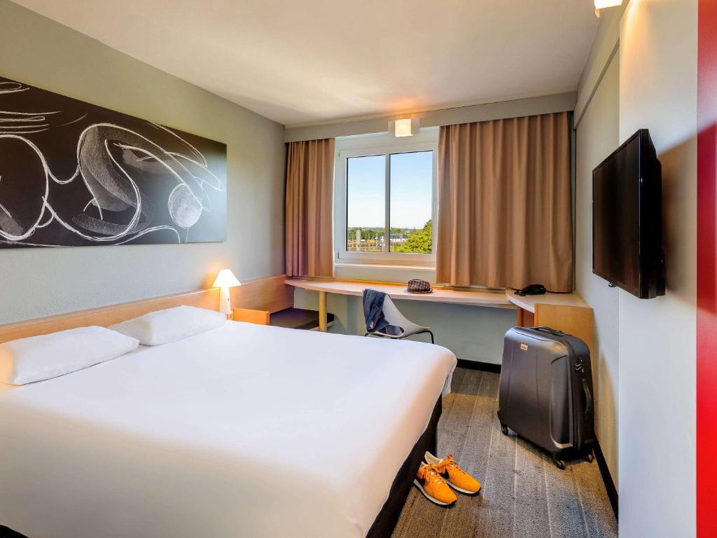 Postel nebo postele na pokoji v ubytování ibis Augsburg Koenigsplatz
