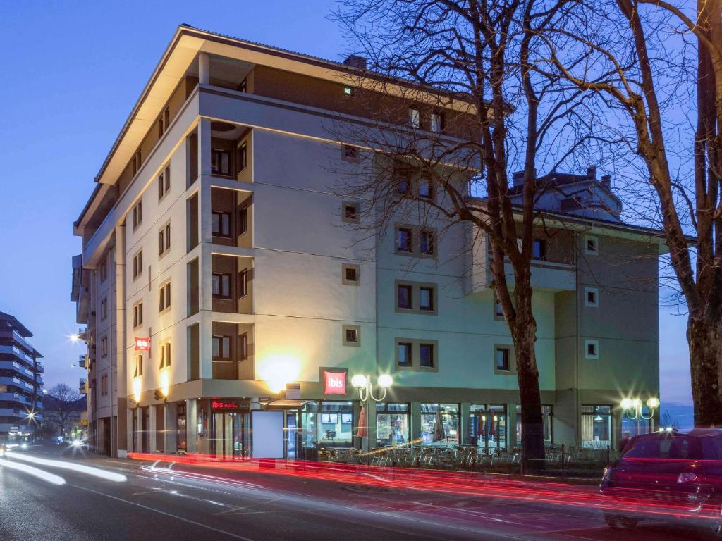 un bâtiment situé sur le côté d'une rue la nuit dans l'établissement ibis Thonon Centre, à Thonon-les-Bains