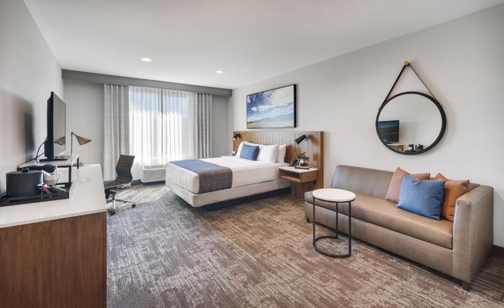 ビスタにあるAyres Hotel Vista Carlsbadのベッドとソファ付きのホテルルーム