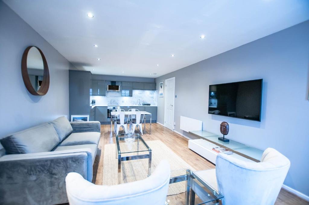a living room with a couch and a tv at Stunning 2 Bed Merchant City Apartment with Residents Parking (Bell 2) in Glasgow