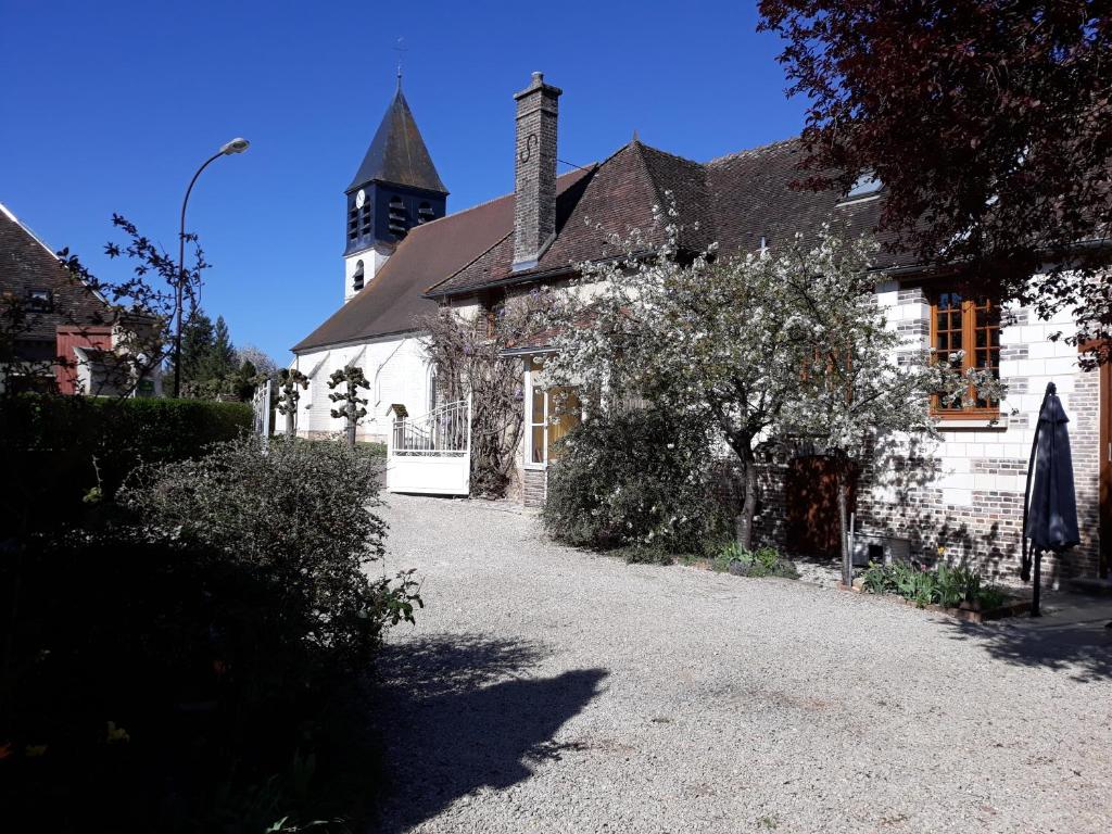 La maison d'Eléonore في Chennegy: مبنى أبيض مع برج الساعة في الخلفية