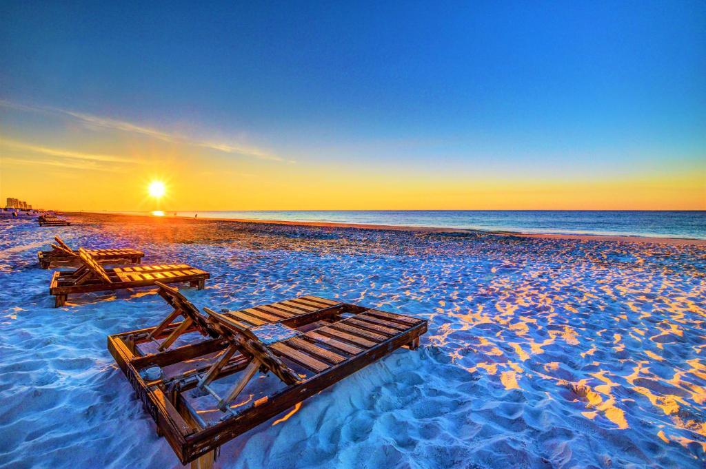 two lounge chairs on a beach at sunset at Beautiful 3 Bedroom BEACHFRONT Condo (F3) - Sleeps 10 in Gulf Shores