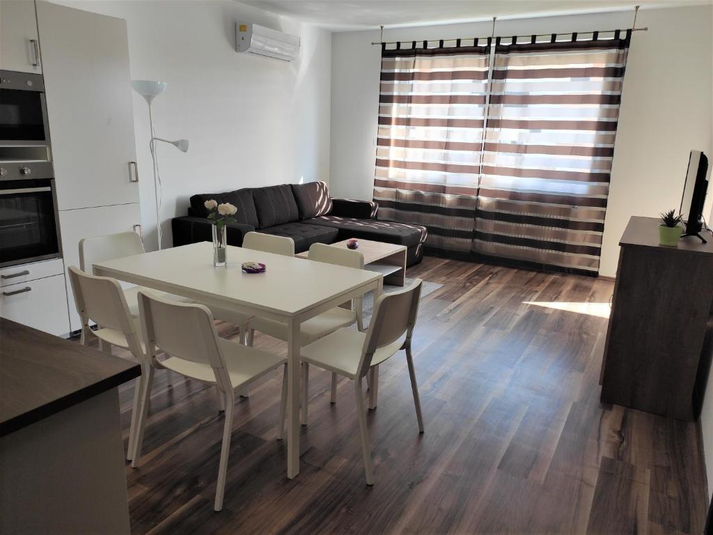 - un salon avec une table, des chaises et un canapé dans l'établissement Hatvan Corner Apartments 2, à Debrecen
