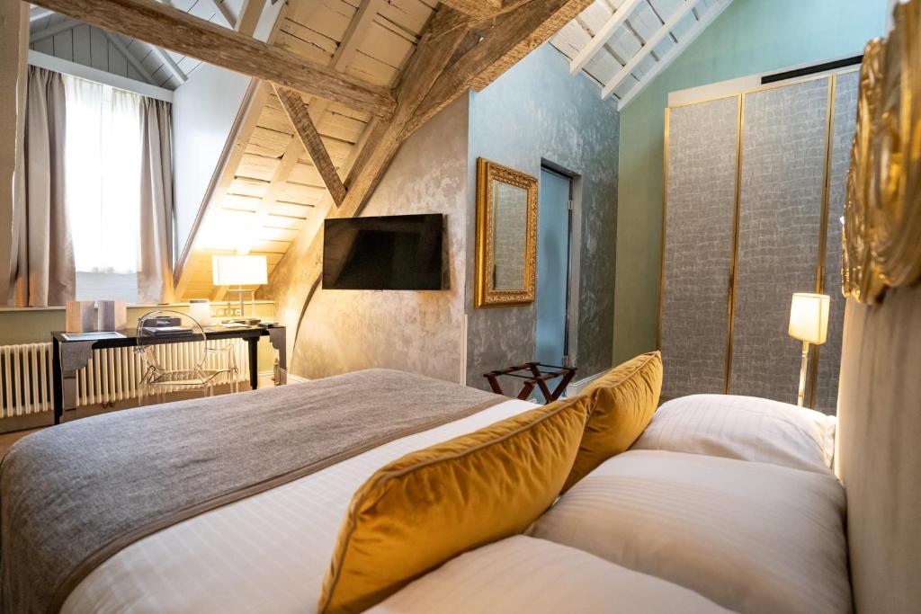 En eller flere senge i et værelse på Hotel Le Place d'Armes - Relais & Châteaux