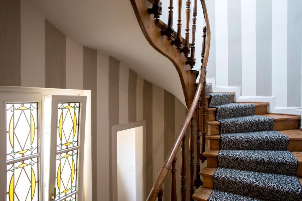 a staircase in a house with stained glass windows at Hotel Le Place d'Armes - Relais & Châteaux in Luxembourg