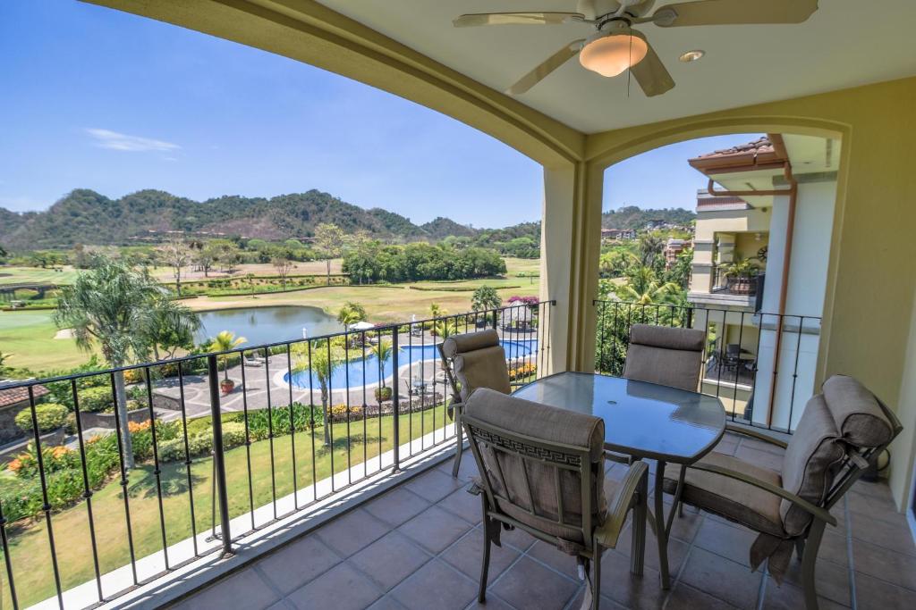 a balcony with a table and chairs and a view of a pool at Los Suenos Resort Del Mar 3C by Stay in CR in Herradura