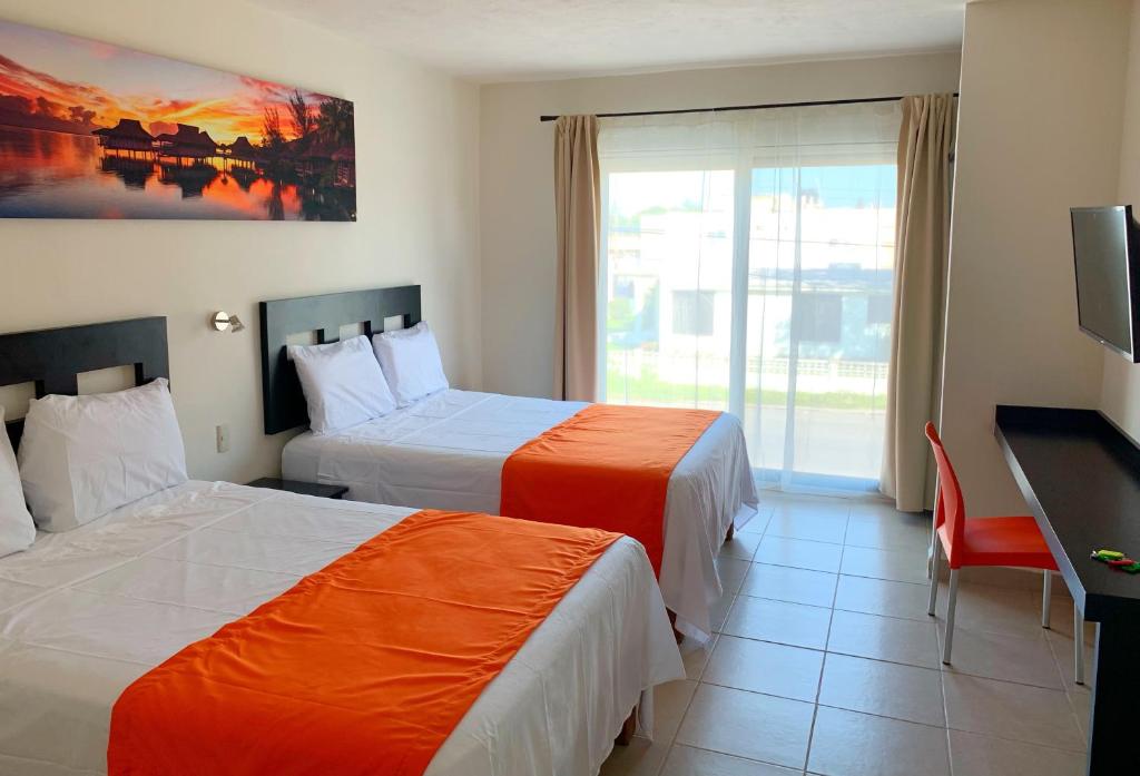 Cette chambre comprend deux lits et une télévision. dans l'établissement Hotel Diez, à Tampico