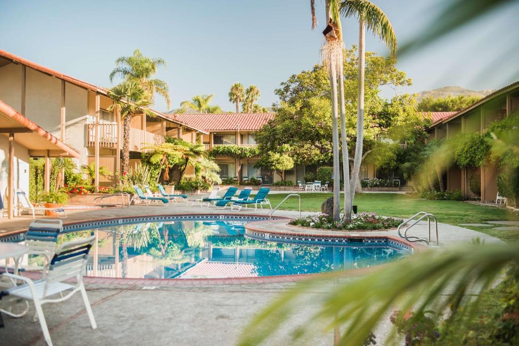 a pool at a resort with chairs and palm trees at Best Western Plus Pepper Tree Inn in Santa Barbara