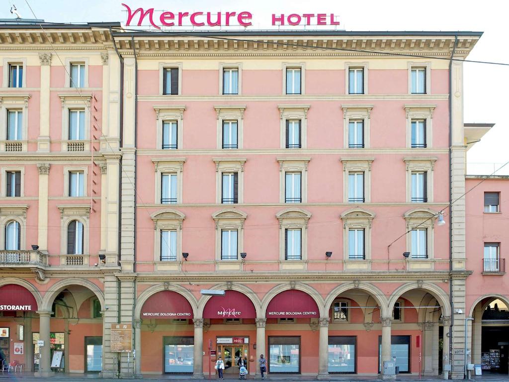 a large building with two windows and a clock on the side of it at Mercure Bologna Centro in Bologna
