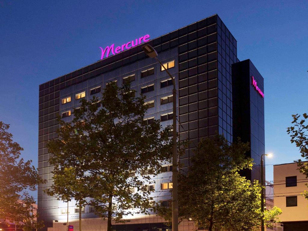 a building with a neon sign on top of it at Mercure Hotel Den Haag Central in The Hague