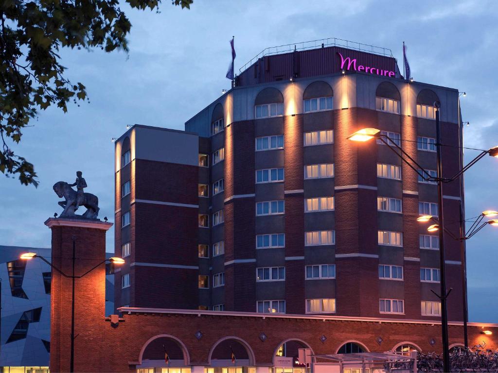 een hotelgebouw met een standbeeld erop bij Mercure Hotel Nijmegen Centre in Nijmegen