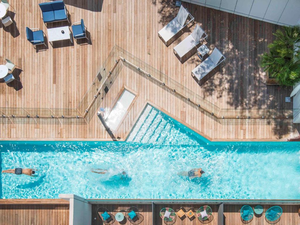 an overhead view of a swimming pool with people in it at Mercure Ajaccio in Ajaccio