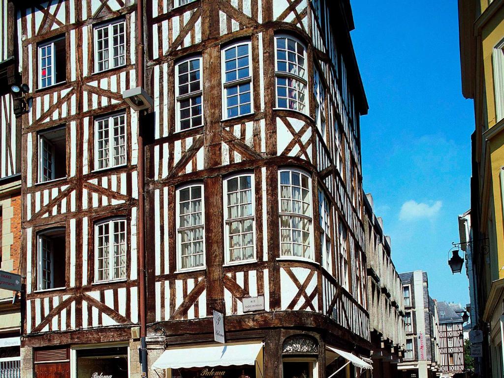 a tall building with white windows on a street at Mercure Rouen Centre Cathédrale in Rouen