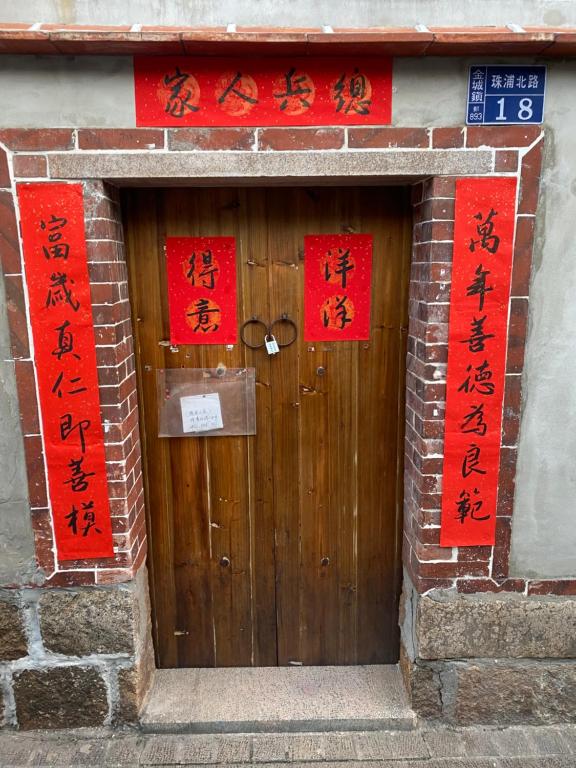 a wooden door with chinese writing on it at House by the Well 總兵人家 in Jincheng
