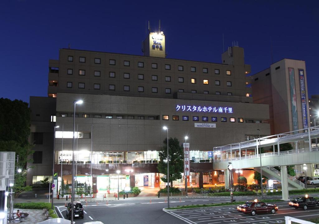 un grand bâtiment avec une tour d'horloge en haut dans l'établissement Minamisenri Crystal Hotel, à Suita