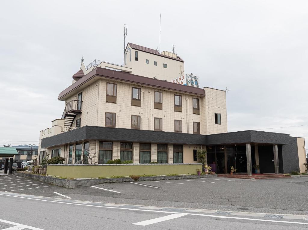 un edificio en la esquina de un estacionamiento en Tabist Hotel Kurama Hikone, en Takamiya