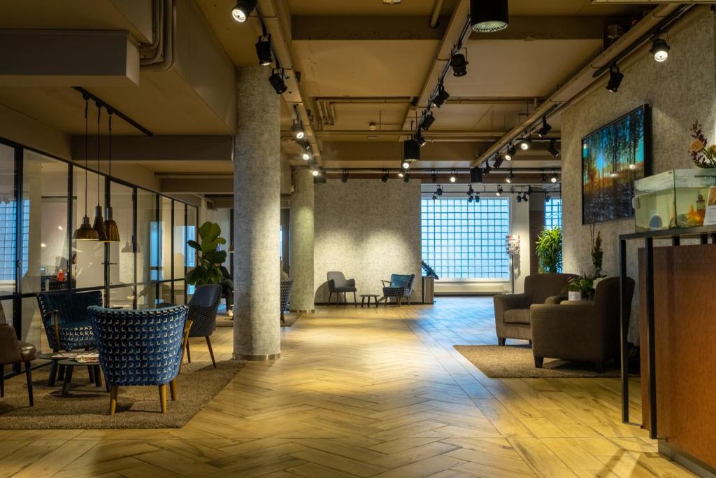 een lobby met banken en stoelen in een gebouw bij Skotel The Hague, Hotelschool The Hague in Scheveningen