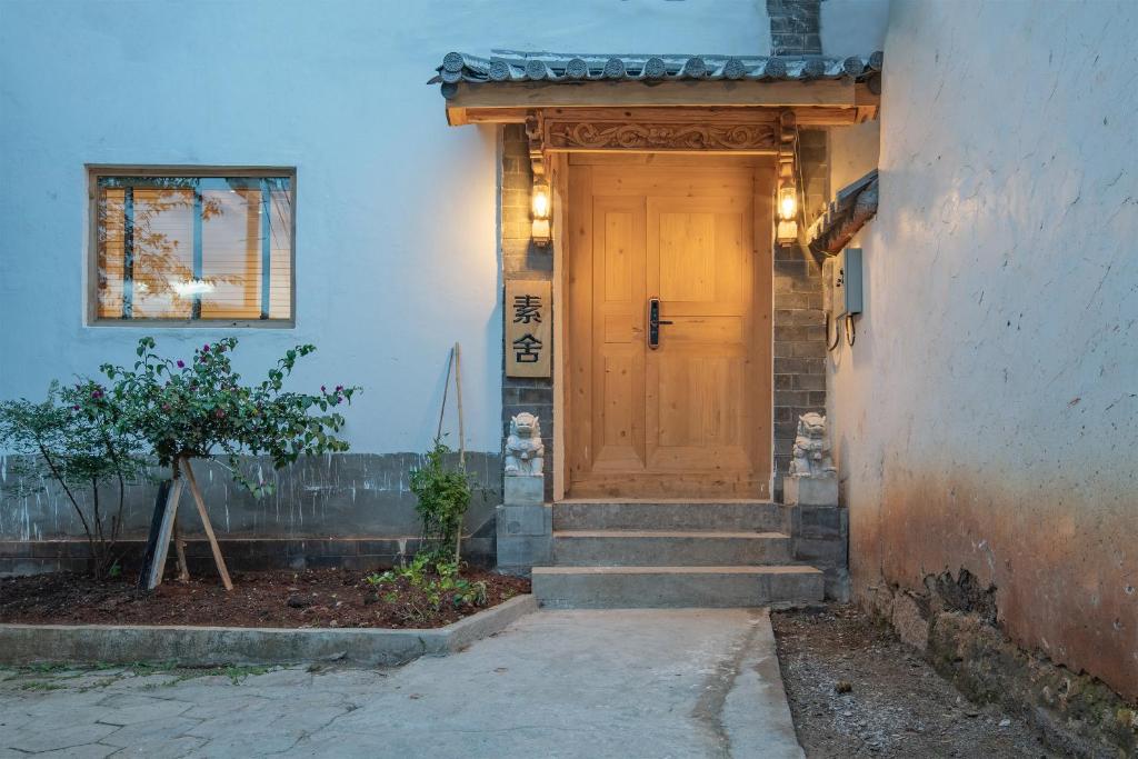 a wooden door on the side of a house at SuShe Inn（2nd Jianshe Inn) in Lijiang