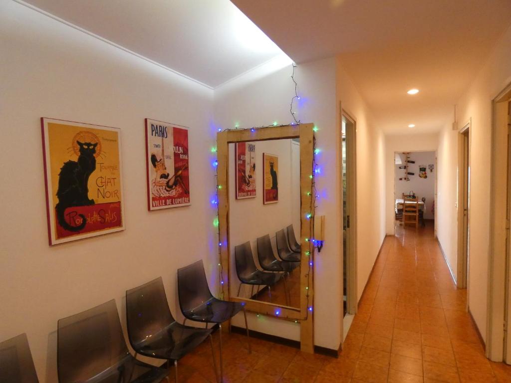 a hallway with chairs and a mirror with lights at Holiday House in Santa Severina