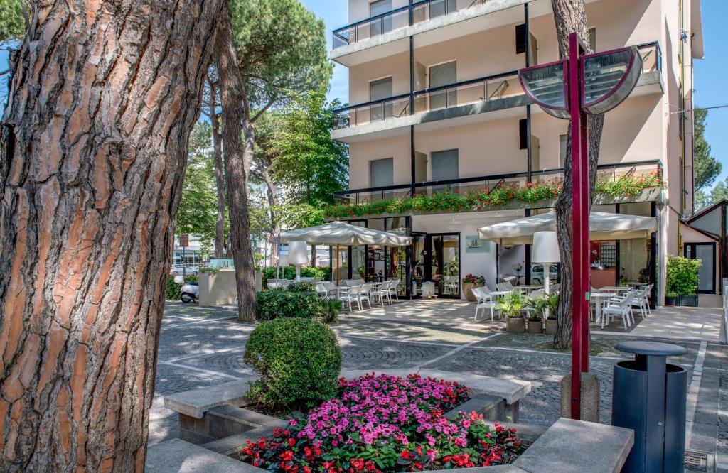 a tree and flowers in front of a building at Hotel Morotti in Misano Adriatico