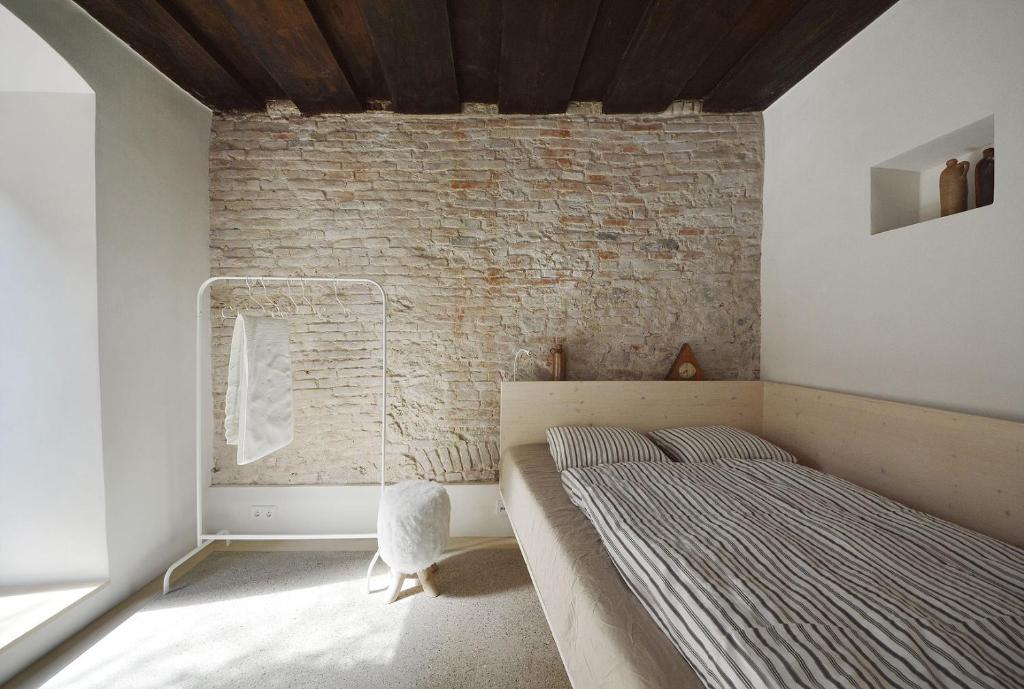 a bedroom with a bed and a brick wall at HÜBSCHES APARTMENT im Herzen von Linz in Linz