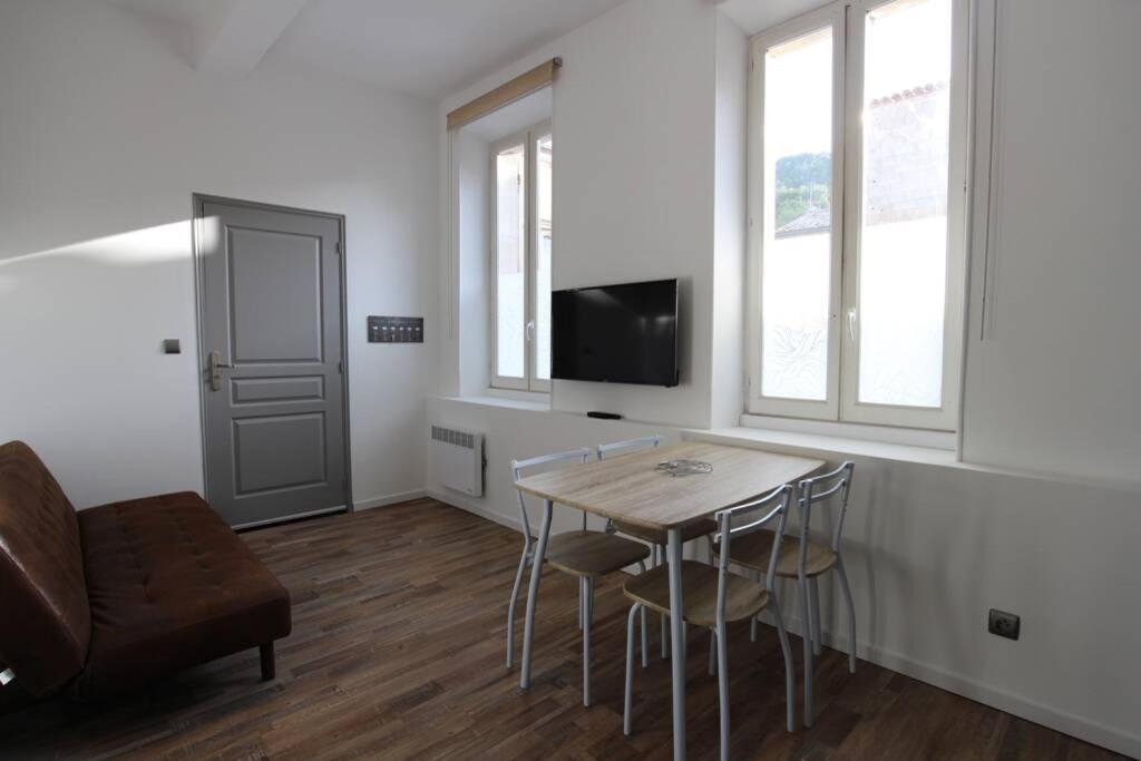 ein Wohnzimmer mit einem Tisch und Stühlen sowie einem TV in der Unterkunft Studio proche de la mer in Portel-des-Corbières