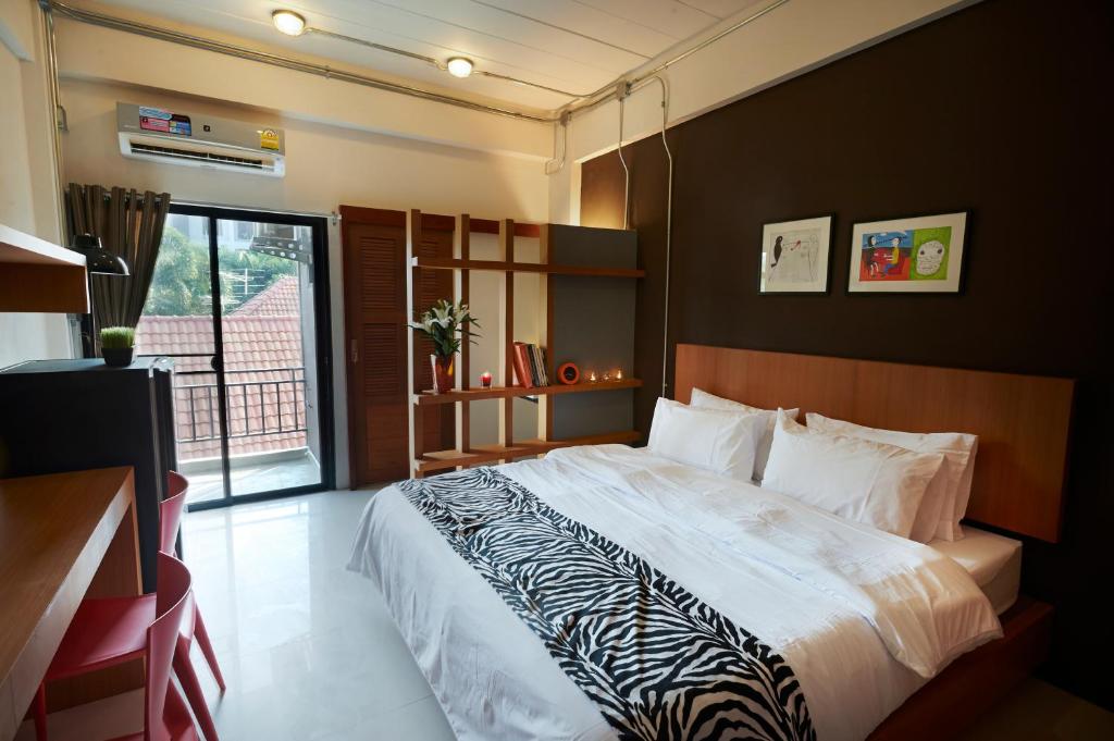 Un dormitorio con una cama grande y una ventana en Euanjitt Chill House, en Khon Kaen