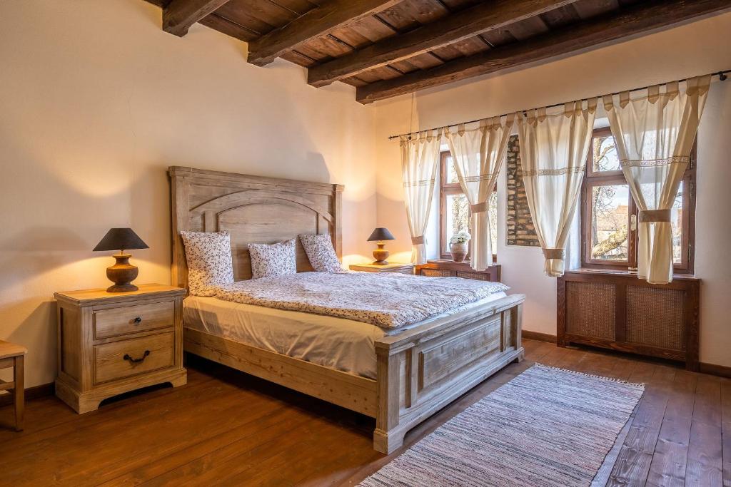 a bedroom with a large bed and two windows at Casa Schmidt in Criţ