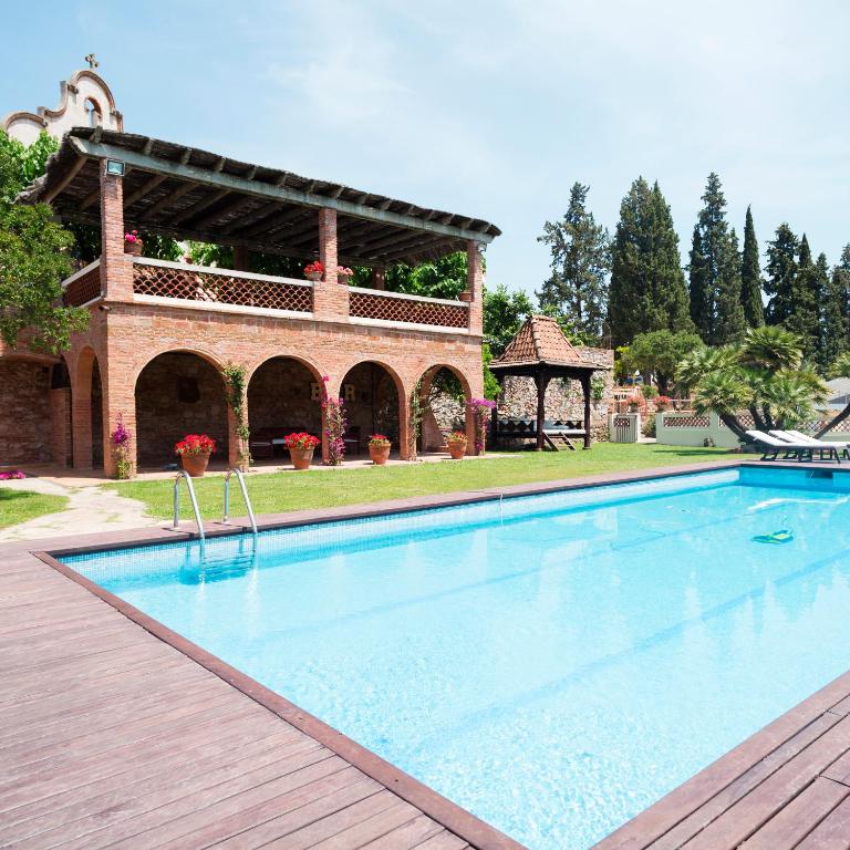 a large swimming pool in front of a house at Can Borrell Villa Carmen in Castellar